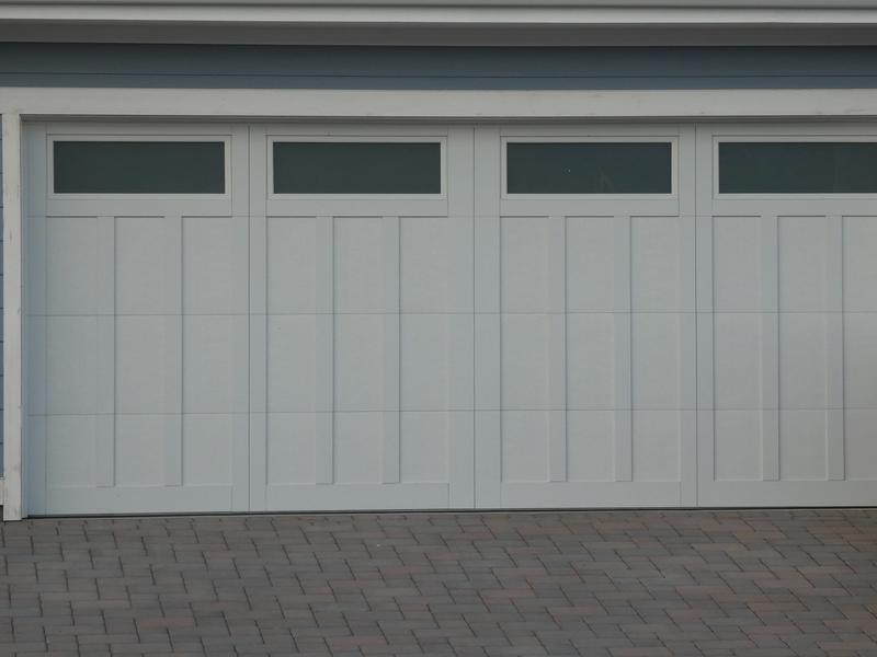 White carriage door, tall panels, top windows, double door, in a lap siding wall