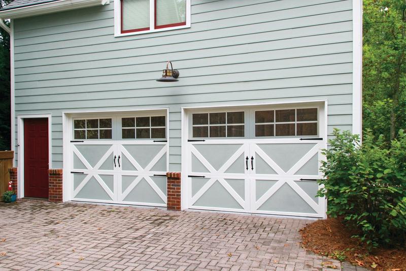 Gray carriage door, X braces, square windows, two single doors, in a lap siding wall