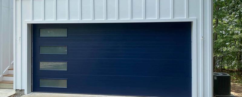 Blue flat door, side window slits, double door, in a board-and-batten wall
