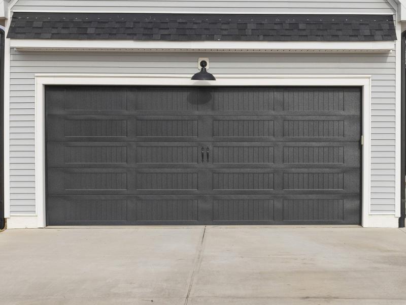 Charcoal raised panel door, grooved panels, black handles, double door, in a lap siding wall