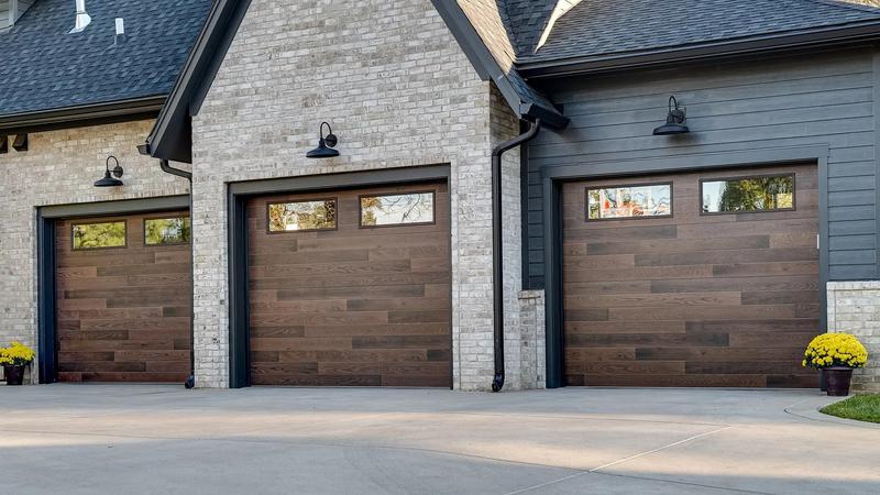 Dark wood plank door, horizontal planks, three single doors, in a brick wall