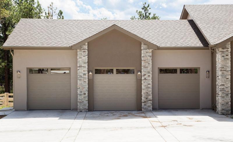 Sandtone flat door, top windows, three single doors, in a stucco wall