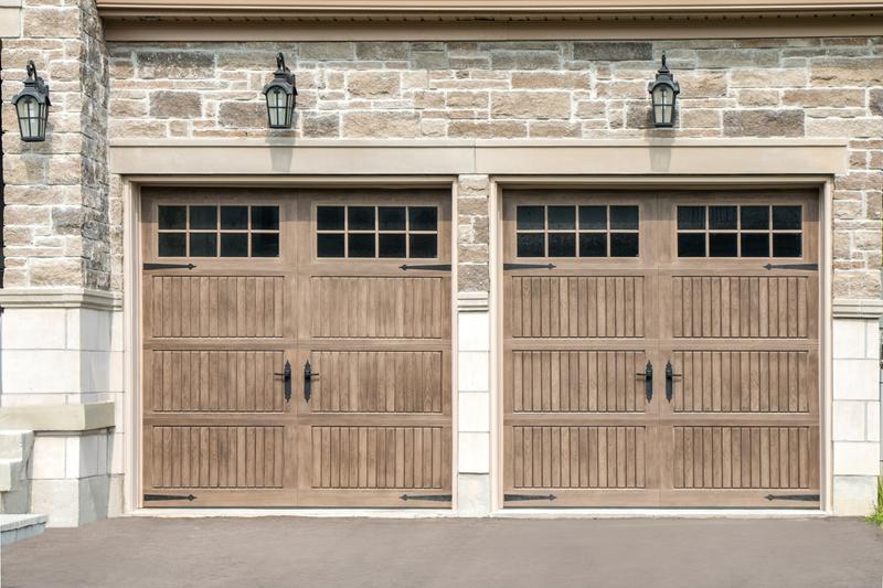 Medium wood raised panel door, square windows, strap hinges, two single doors, in a stone wall
