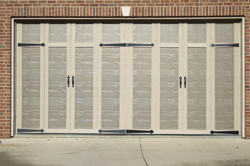 Sandtone carriage door, vertical boards, strap hinges, double door, in a brick wall