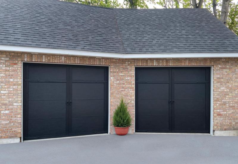 Black carriage door, tall panels, two single doors, in a brick wall