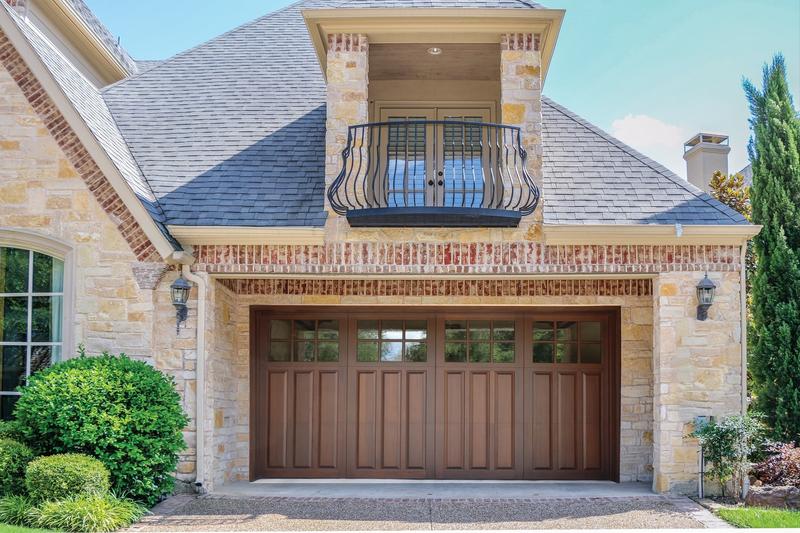 Medium wood door with raised panels, square windows, on a stone home, double door, in a stone wall