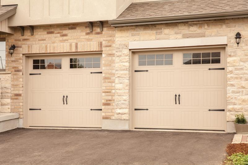 Almond raised panel door, square windows, strap hinges, two single doors, in a stone wall