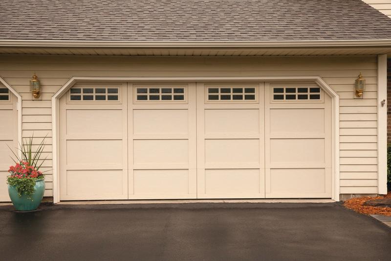 Almond carriage door, tall panels, square windows, double door, in a lap siding wall