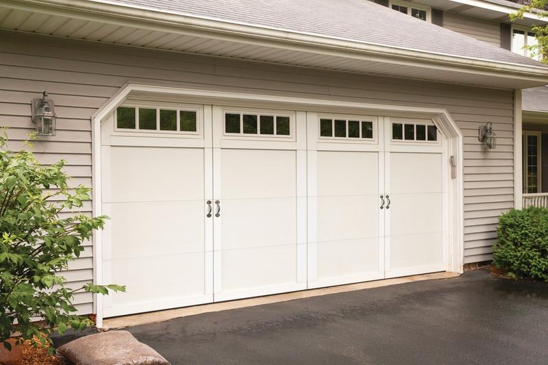 White carriage door, tall panels, square windows, double door, in a lap siding wall
